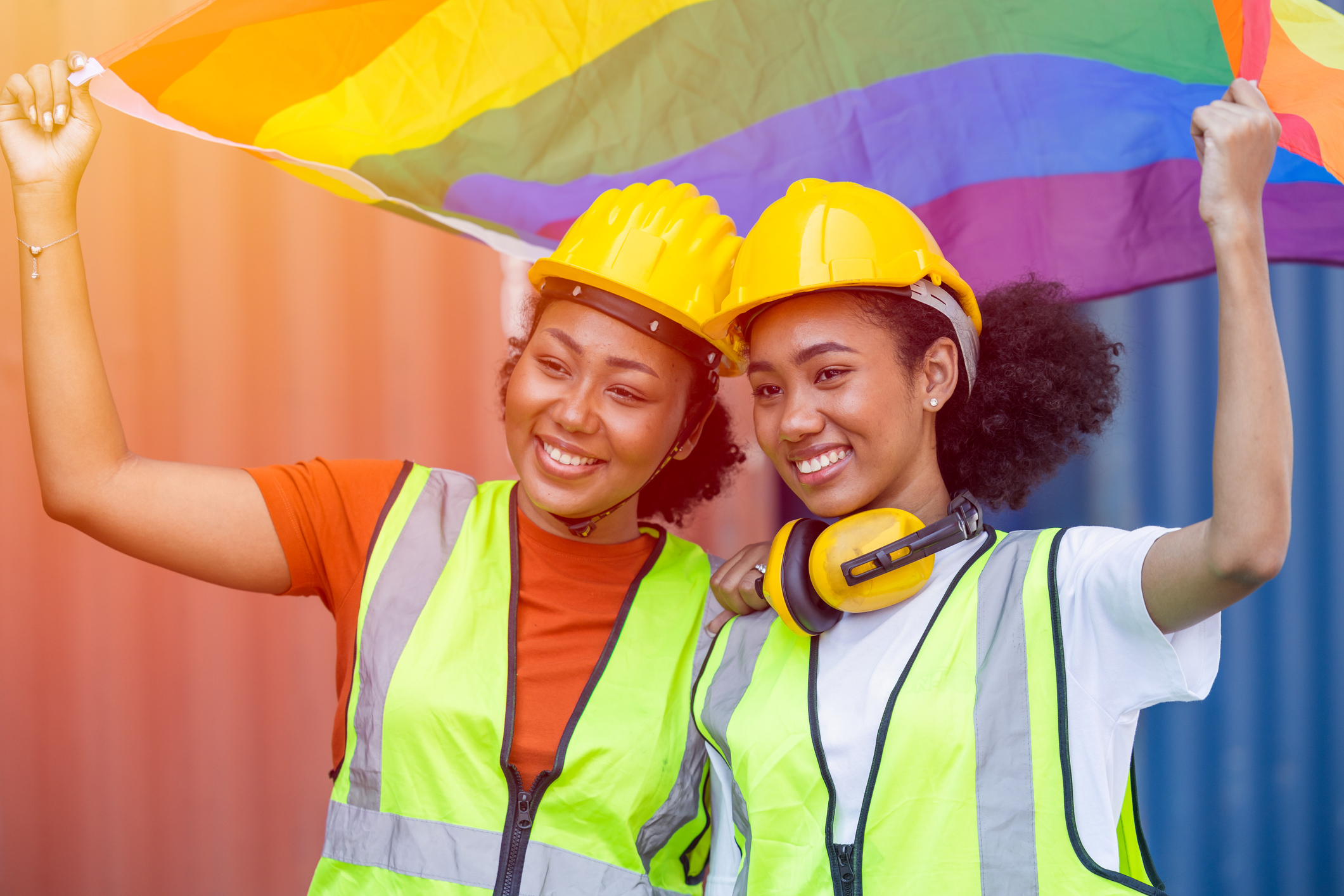 Women workers holding rainbow LGBTQ flag